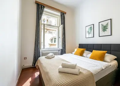a bedroom with a large bed with yellow pillows on it at Golden Prague Residence, Jáchymova Street in Prague