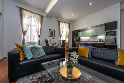 a living room with a black leather couch at Spacious elegant apartment at the Old Town Square in Prague