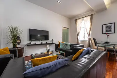 a living room with a couch and a tv at Spacious elegant apartment at the Old Town Square in Prague