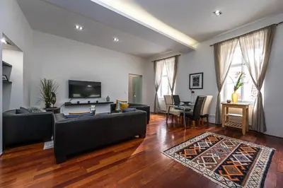 a living room with a black couch and a table at Spacious elegant apartment at the Old Town Square in Prague