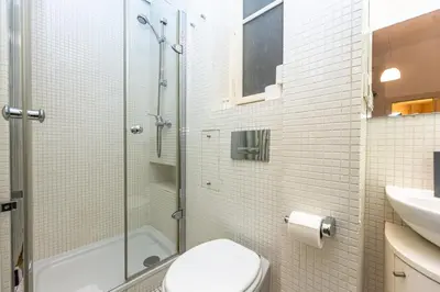 a bathroom with a shower and a toilet and a sink at Bohemian charm apartment by Paris Avenue 1 in Prague