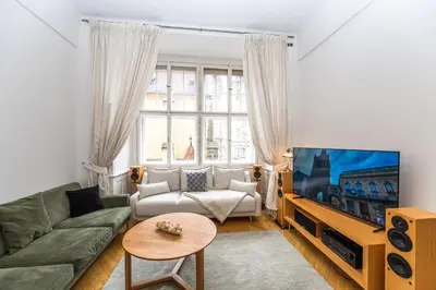 a living room with a couch and a tv at Bohemian charm apartment by Paris Avenue 1 in Prague