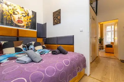 a bedroom with a large purple bed with pillows at Charm Vinohrady in Prague