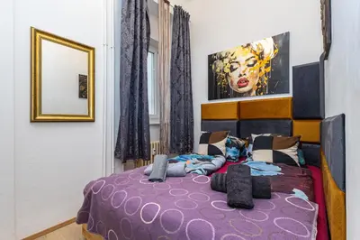 a bedroom with a purple bed and a mirror at Charm Vinohrady in Prague
