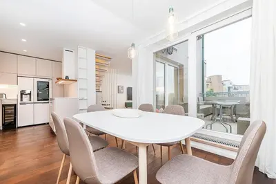 a kitchen and dining room with a white table and chairs at Amazing 3-Bedroom and Terrace overlooking TV Tower in Prague