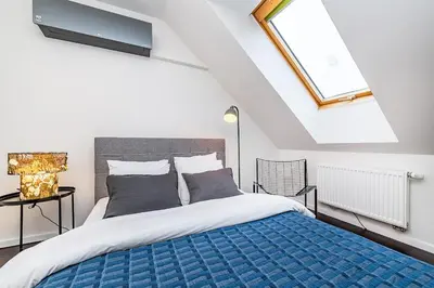 a bedroom with a bed with a blue blanket at Amazing 3-Bedroom and Terrace overlooking TV Tower in Prague