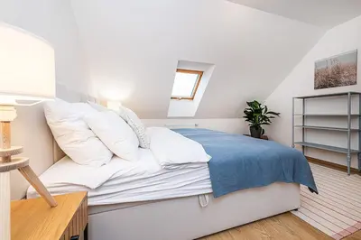 a bedroom with a bed with white sheets and pillows at Amazing 3-Bedroom and Terrace overlooking TV Tower in Prague