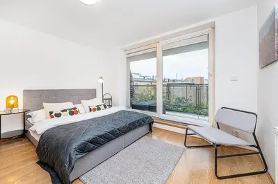 a bedroom with a large bed and a large window at Amazing 3-Bedroom and Terrace overlooking TV Tower in Prague