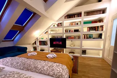 a bedroom with a bed and a book wall at Central Cozy Comfort Loft in Prague