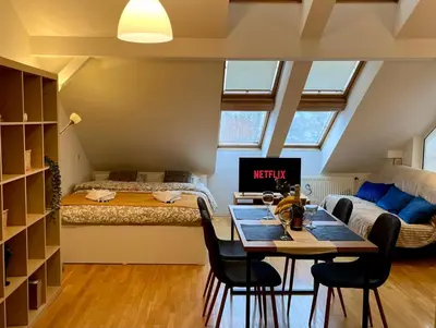 a room with a bed and a table and chairs at Central Cozy Comfort Loft in Prague