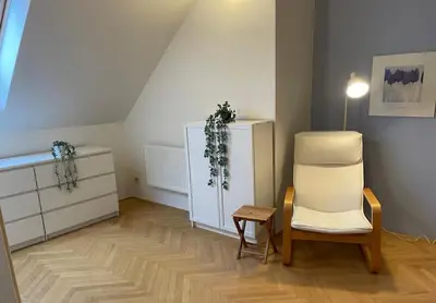 a living room with a chair and a dresser at Central Cozy Comfort Loft in Prague