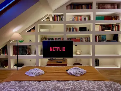 a bedroom with a bed with a television on it at Central Cozy Comfort Loft in Prague
