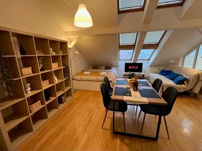 a living room with a table and chairs and a bedroom at Central Cozy Comfort Loft in Prague