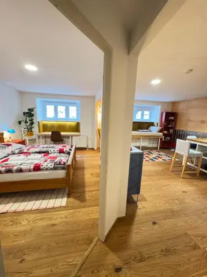 a bedroom with a bed and a living room at Negroni Apartment in Prague