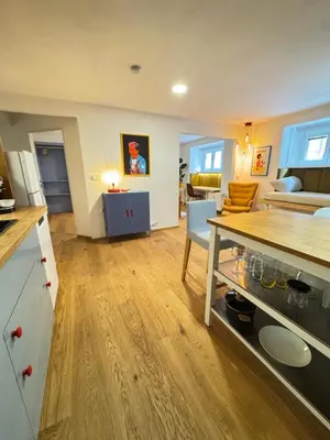 a kitchen and living room with a table and a couch at Negroni Apartment in Prague