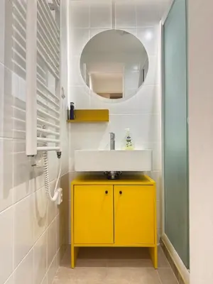 a bathroom with a yellow sink and a mirror at Negroni Apartment in Prague