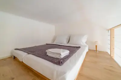 a white bed with a pile of towels on it at Charming Apartment in the Heart of Prague by Rentez in Prague