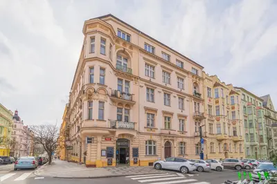 a large building with cars parked in front of it at Charming Apartment in the Heart of Prague by Rentez in Prague