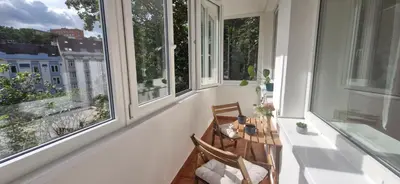 a balcony with a wooden chair in front of windows at Prague Green Hideaway near Centre in Prague