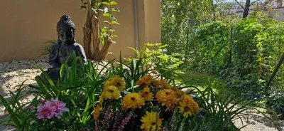 a garden with a statue in the middle of flowers at Prague Green Hideaway near Centre in Prague