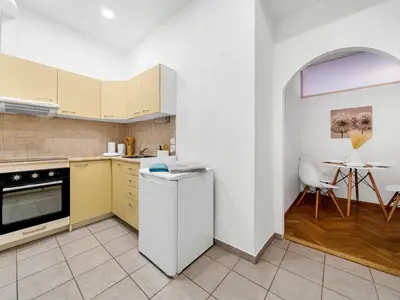 a kitchen with a white refrigerator and a table at Spacious & Modern Apartment by Wenceslas Square in Prague