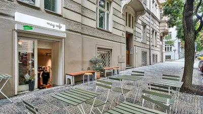 a street with chairs and tables in front of a building at Spacious & Modern Apartment by Wenceslas Square in Prague