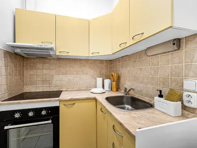 a kitchen with yellow cabinets and a sink at Spacious & Modern Apartment by Wenceslas Square in Prague