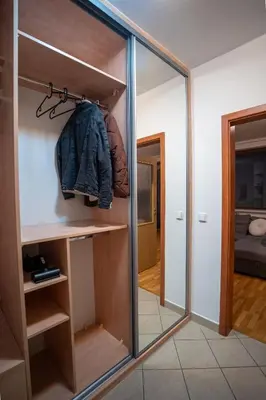 a sliding glass door in a room with a mirror at Světlý byt blízko centra - plně vybavený in Prague
