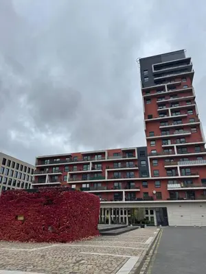 a tall red building with a red hedge in front of it at Světlý byt blízko centra - plně vybavený in Prague