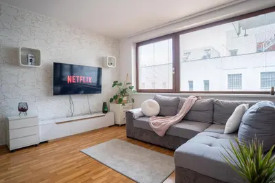 a living room with a couch and a tv at Světlý byt blízko centra - plně vybavený in Prague