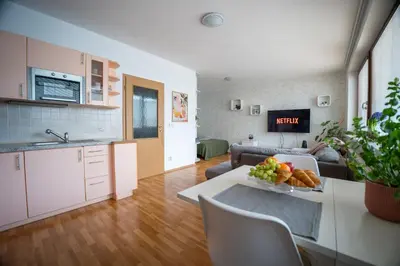 a kitchen and living room with a table with a bowl of fruit at Světlý byt blízko centra - plně vybavený in Prague
