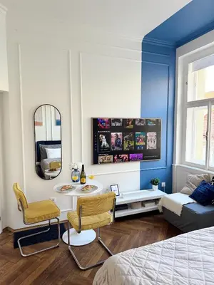 a room with a bed and a table and a mirror at Old Town Blue Apartment in Prague