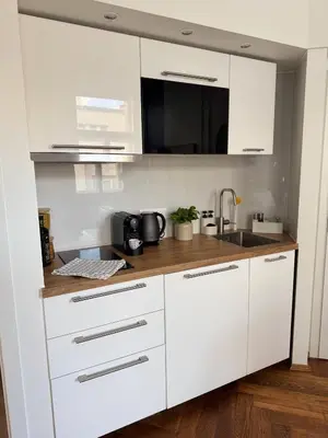a kitchen with white cabinets and a sink at Old Town Blue Apartment in Prague