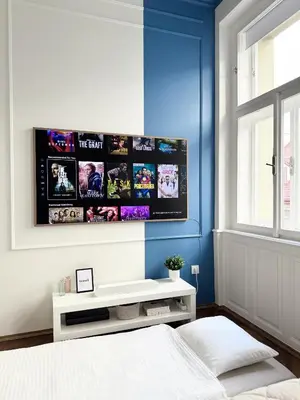 a bedroom with a blue wall with a tv on the wall at Old Town Blue Apartment in Prague