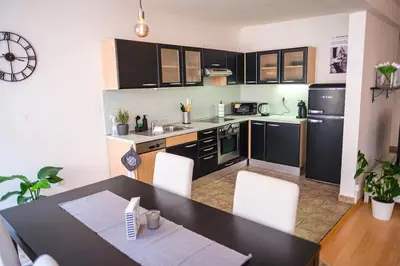 a kitchen with a table and white chairs in a room at Spacious 8-Person Apartment in the Heart of Prague in Prague