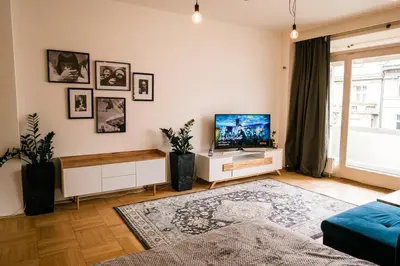 a living room with a flat screen tv on a wall at Bright 120m apartment 2BR Balconies near Castle in Prague
