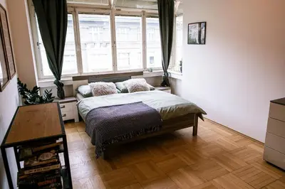 a bedroom with a bed and a large window at Bright 120m apartment 2BR Balconies near Castle in Prague