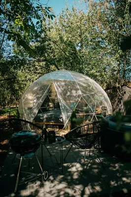 a table and chairs under a clear umbrella at Forest Home Okoř in Okoř