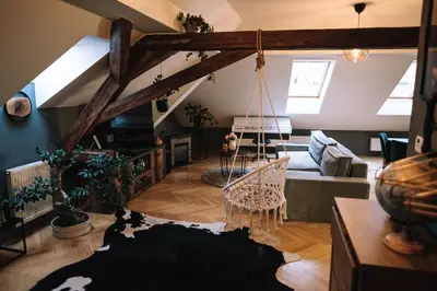 a living room with a couch and a swing at Charming Attic Apartment in the Heart of Prague in Prague