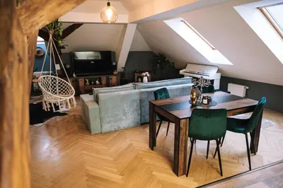 a living room with a table and a couch at Charming Attic Apartment in the Heart of Prague in Prague