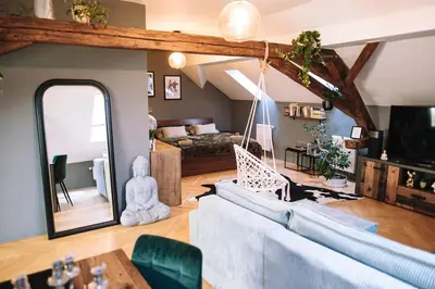 a living room with a couch and a mirror at Charming Attic Apartment in the Heart of Prague in Prague
