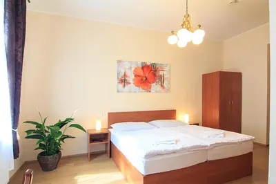 a bedroom with a bed with a red flower painting on the wall at Penzion U Čejpu in Prague