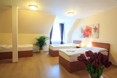 a room with two beds and a vase of flowers at Penzion U Čejpu in Prague