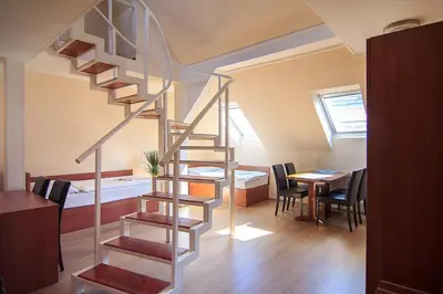 a spiral staircase in a room with a table and chairs at Penzion U Čejpu in Prague