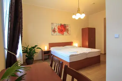 a bedroom with a bed and a table and a dining room at Penzion U Čejpu in Prague