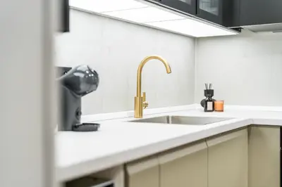 a kitchen with a sink and a faucet at Rentero Lublanska Residence - Stylish Lofts in Prague