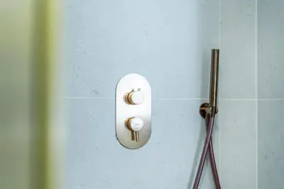 a white switch on a wall in a bathroom at Rentero Lublanska Residence - Stylish Lofts in Prague