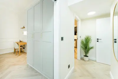 a white hallway with white cabinets and a table at Rentero Lublanska Residence - Stylish Lofts in Prague