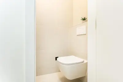 a bathroom with a white toilet in a room at Rentero Lublanska Residence - Stylish Lofts in Prague