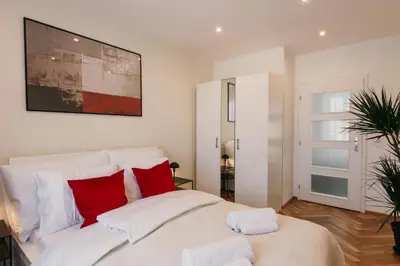 a bedroom with a large white bed with red pillows at Maisonette with terrace and view of Prague Castle in Prague